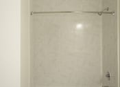 Thumbnail 26 of 31 - A white toilet is in a bathroom with a marble wall.