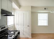 Thumbnail 12 of 31 - A kitchen with a stove and a door.