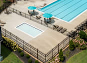 Thumbnail 7 of 31 - A black fence surrounds a small pool with a blue umbrella.