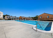 Thumbnail 5 of 31 - A swimming pool with a blue water and a white fence around it.
