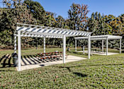 Thumbnail 28 of 31 - A white and black striped canopy shades a picnic table.