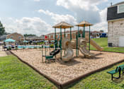 Thumbnail 29 of 31 - A playground with a slide, swings, and a climbing frame.