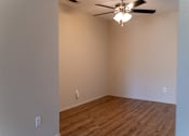 Thumbnail 4 of 22 - an empty living room with a ceiling fan and wood floors at Cowell Terrace Apartments, Concord California