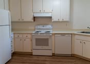 Thumbnail 16 of 22 - an empty kitchen with white cabinets and a stove and refrigerator at Cowell Terrace Apartments, Concord, 94518