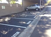 Thumbnail 13 of 22 - the side of a black wall with a car parked next to it at Cowell Terrace Apartments, California, 94518