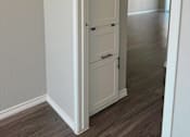 Thumbnail 15 of 33 - an open white door leading into a hallway with a wood floor