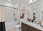 Thumbnail 35 of 40 - A bathroom with a white toilet, a sink, and a shower.