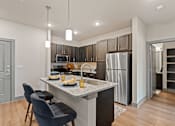 Thumbnail 9 of 19 - A modern kitchen with a dining table set for two.