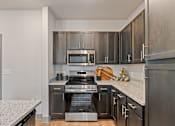 Thumbnail 10 of 19 - A modern kitchen with a stainless steel oven and microwave.