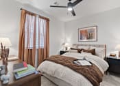 Thumbnail 31 of 40 - A bedroom with a large bed and a ceiling fan.