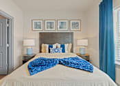 Thumbnail 7 of 19 - A bedroom with a large bed and a blue blanket.
