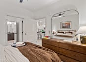 Thumbnail 32 of 40 - A bedroom with a bed, a dresser, and a mirror.