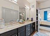 Thumbnail 8 of 19 - A bathroom with a sink, mirror, and a large cabinet.