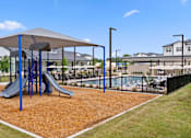 Thumbnail 6 of 40 - A playground with a slide and a swing set.