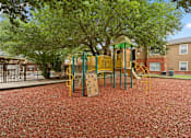 Thumbnail 19 of 38 - A playground with a yellow and green swing set.