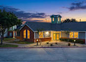 Thumbnail 3 of 23 - A building with a green dome and lit windows at dusk.