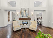 Thumbnail 14 of 27 - A living room with a fireplace and two chairs.
