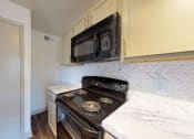 Thumbnail 10 of 60 - a kitchen with a stove and a microwave