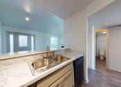 Thumbnail 17 of 60 - Kitchen sink surrounded by white countertops and looking into living room