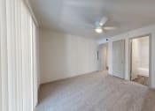 Thumbnail 28 of 60 - a bedroom with carpet and a ceiling fan and a door to a bathroom
