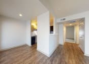 Thumbnail 25 of 60 - a living room and kitchen with a wood floor and white walls