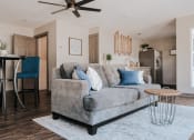 Thumbnail 56 of 60 - a living room with a gray couch and a dining room table