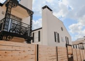 Thumbnail 48 of 60 - a white building with a wooden fence in front of it