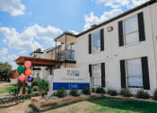 Thumbnail 42 of 60 - a white brick building with balloons in front of it
