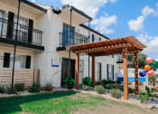 Thumbnail 39 of 60 - the exterior of a building with a pergola and grass