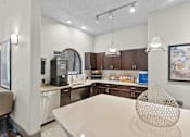Thumbnail 12 of 27 - A modern kitchen with a dining table and a coffee machine.