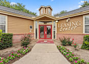 Thumbnail 17 of 38 - A building with a red door and a sign that says "Leasing Center".