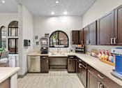 Thumbnail 11 of 27 - A kitchen with brown cabinets and a white counter.