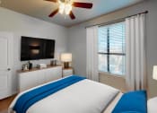 Thumbnail 4 of 22 - a bedroom with a bed and a ceiling fan and a tv