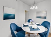 Thumbnail 6 of 22 - a dining room with a white table and blue chairs