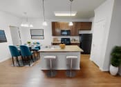 Thumbnail 5 of 22 - a kitchen and dining room area with a table and chairs and a refrigerator and microwave