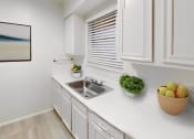 Thumbnail 6 of 16 - a kitchen with white cabinets and a sink