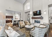 Thumbnail 10 of 27 - A living room with a grey couch and a fireplace.