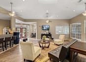 Thumbnail 14 of 38 - A living room with a bar area and a television.