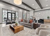 Thumbnail 5 of 19 - A modern living room with a large grey sofa, a wooden coffee table, and a fireplace.
