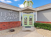 Thumbnail 23 of 23 - A building with a green door and a sign that says Leasing Center.