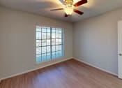 Thumbnail 21 of 22 - an empty living room with a large window and a ceiling fan