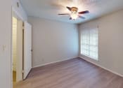 Thumbnail 20 of 22 - an empty living room with a ceiling fan and a window