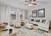 Thumbnail 19 of 27 - A living room with a white sofa, two chairs, and a rug.
