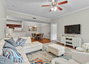 Thumbnail 22 of 27 - A living room with a white couch and a ceiling fan.