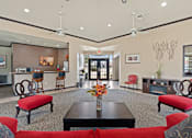 Thumbnail 11 of 23 - A living room with a red couch and a black coffee table.