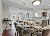 Thumbnail 18 of 27 - A modern dining room with a glass table and grey chairs.