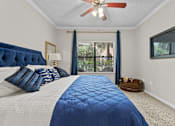 Thumbnail 20 of 27 - A bedroom with a large bed and a ceiling fan.