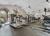 Thumbnail 23 of 27 - A gym with treadmills, weights, and exercise machines.