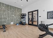 Thumbnail 8 of 40 - A gym with a rowing machine in the foreground.