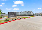 Thumbnail 3 of 40 - A sign that says Tapestry in front of some buildings.